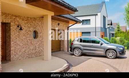 Maison d'habitation avec silver suv voiture garée sur la voie d'en face Banque D'Images