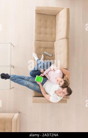 Jeune couple dans la salle de séjour à l'aide de tablet vue supérieure Banque D'Images