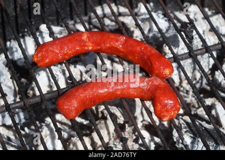 Deux merguez grillées sur le rack d'un barbecue Banque D'Images