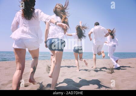 Groupe des gens heureux s'amuser et courir sur la plage Banque D'Images