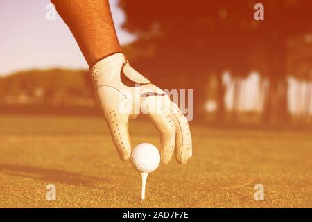 Close up de joueurs de golf ball on tee main mise Banque D'Images