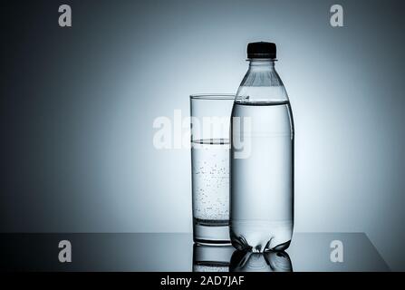 Bouteille en plastique et en verre avec de l'eau Banque D'Images