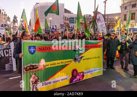 Londres, Royaume-Uni. 3e décembre 2019. Kurdes tenir une bannière avec peopme sur l'OTAN et l'invasion turque. Une grande foule écouter des discours à Trafalgar Square pour protester contre la visite d'Atout à l'UK et de l'OTAN. Parmi eux se trouvaient ceux qui défendent la NHS contre la privatisation et d'ouverture à propos de sociétés médicales et médicaments à prix élevé, de kurdes protestant contre l'invasion d'Erdogan de régions Kurdes de Syrie, les manifestants contre l'emporte sur l'appui d'Israël contre les Palestiniens et contre sa promotion et soutien pour le coup d'État contre le gouvernement démocratiquement élu de Bolivie et les attaques contre les i Banque D'Images