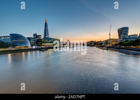 Sur la Tamise à Londres après le coucher du soleil avec les gratte-ciel de la ville et la Tour Banque D'Images