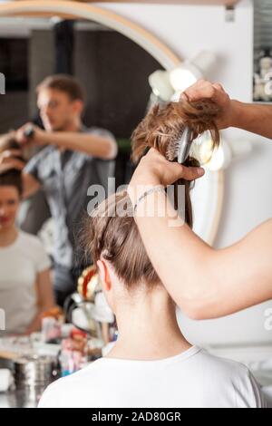 Coiffeur professionnel avec de longs cheveux modèle. Soins des cheveux professionnels. Banque D'Images