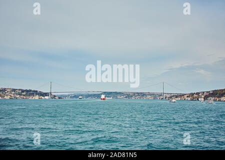 Navires transitant par le pont du Bosphore avec arrière-plan de détroit du Bosphore sur une journée ensoleillée avec le fond nuageux ciel bleu et bleu de la mer à Istanbul, Tu Banque D'Images