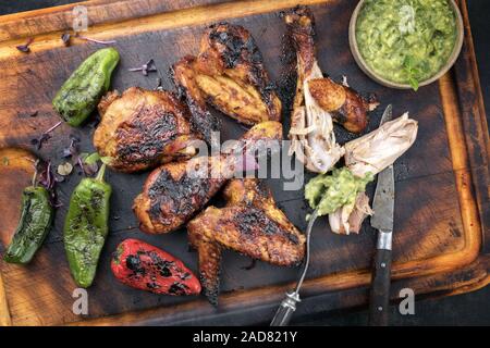 Ailes de poulet barbecue traditionnel des Caraïbes et les pilons avec la sauce Chimichurri Banque D'Images