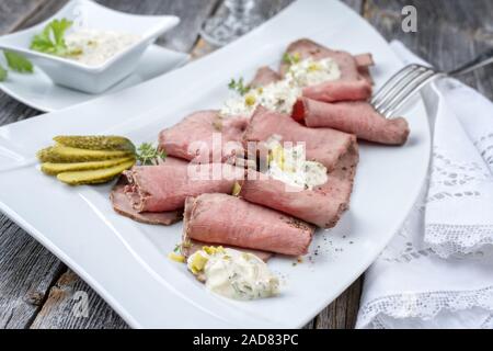 Le déjeuner traditionnel avec des tranches de viande froide et de rosbif sur un gros plan en rémoulade assiette blanche sur une table en bois Banque D'Images