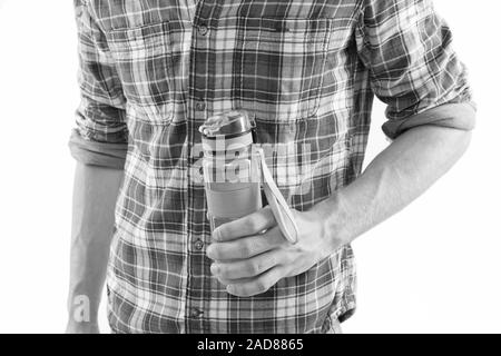 Bouteille réutilisable. Tenir la main ou boire une bouteille d'eau sport fond blanc. Bouteille dans la main des hommes. Le sport et l'équilibre de l'eau concept. Boisson sportive en bouteille. Zéro déchets Eco et de vie. Banque D'Images