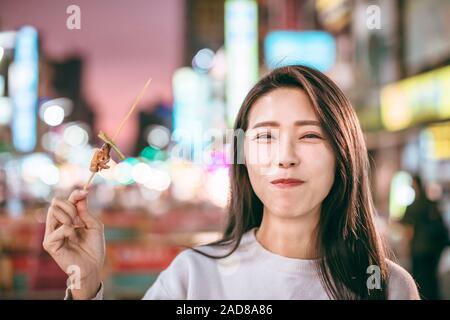 Jeune femme asiatique dans l'alimentation de rue profiter du marché de nuit Banque D'Images