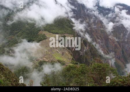 Une vue aérienne, à travers les nuages, de Machu Picchu du haut de Huayna Picchu dans les montagnes des Andes, au Pérou, en Amérique du Sud Banque D'Images