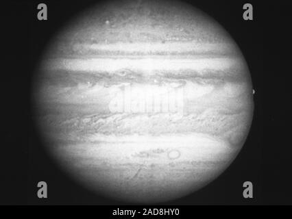 Ce noir et blanc photo de Jupiter, pris en feu vert à 1:14 h le 11 mars, 1991 par la caméra planétaire de la NASA sur le télescope spatial Hubble, montre une richesse de détails dans les nuages qui couvrent la planète. La Grande Tache rouge est visible en bas à droite, également sur la droite près de l'équateur, le satellite Europa est en train de disparaître derrière le limbe de la planète. La sombre nuages en forme de 'j' le long de l'équateur sont le résultat d'un modèle de jet intense d'eau dans l'atmosphère jovienne. Cette photo est aussi nette que le voyager photos prises cinq jours avant l'approche la plus proche en 1979. Banque D'Images