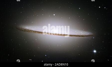 Le télescope Hubble de la NASA a formé ses razor-sharp eye sur l'un de l'univers majestueux et le plus photogénique des galaxies, la galaxie Sombrero, Messier 104 (M104). La marque de la galaxie est un blanc brillant, base bulbeuse encerclée par les bandes de poussière épais comprenant la structure spirale de la galaxie. Comme vu de la Terre, la galaxie est incliné près de côté. Nous visualiser à partir de seulement 6 degrés au nord de son plan équatorial. Cette brillante galaxie a été nommé le Sombrero à cause de sa ressemblance avec le rim large et haute surmontée Mexican Hat. Lors d'une ampleur relativement positive de  +8, M104 n'est qu'être Banque D'Images