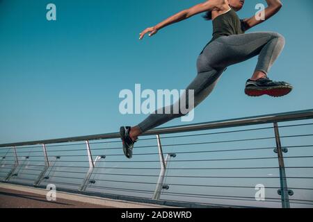 Sportswoman sautant vers le haut dans l'air stock photo Banque D'Images