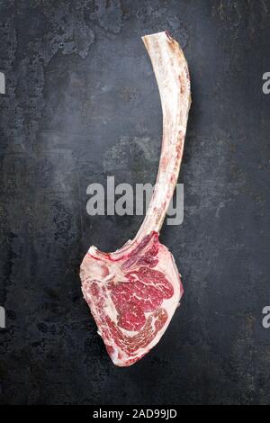 Matières premières traditionnelles de sec tomahawk wagyu steak en vue de dessus sur une vieille carte rustique with copy space Banque D'Images