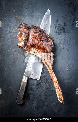 Barbecue traditionnel de sec tomahawk wagyu steak en vue de dessus sur une vieille feuille de métal rustique avec un grand couteau Banque D'Images