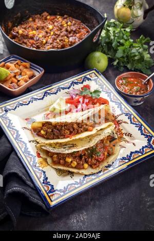 Mijotés traditionnels Mexican chili con canne avec les tortillas comme vue de dessus dans un design moderne plat à rôtir en fonte Banque D'Images