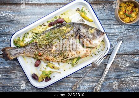 Barbecue frais la daurade royale avec Chutney de mangues et pesto en vue de dessus dans une poêle blanc Banque D'Images