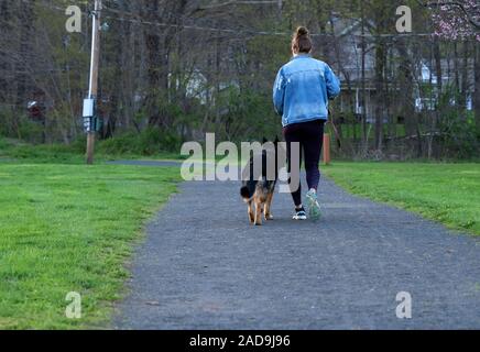 2229 CT USA. Apr 2019. Femme et chien en laisse courir à un parc de la Nouvelle-Angleterre. Banque D'Images