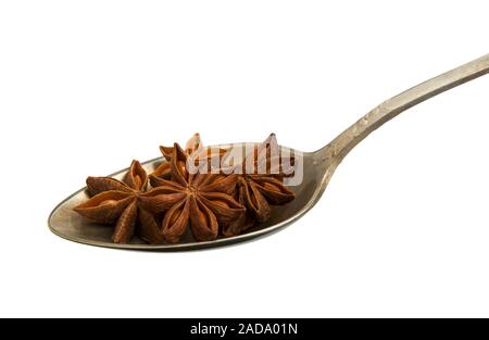 Anis en une vieille cuiller isolé sur un fond blanc. Isoler sur l'assaisonnement. Vue de dessus. Les graines d'anis étoilé sur l'isoler. Banque D'Images