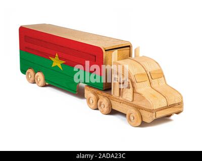 Close-up d'un camion jouet en bois peint avec un drapeau national au Burkina Faso. Le concept d'exportation-importation, transport, livraison de marchandises nationales Banque D'Images