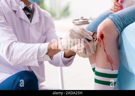 Jeune femme blessés jambe homme médecin visite Banque D'Images