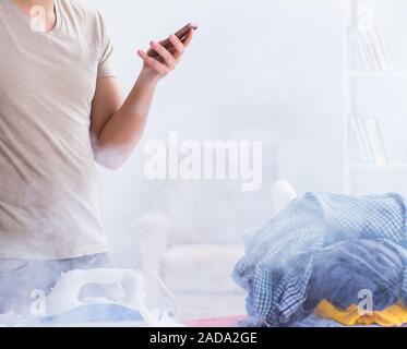 Mari inattentif pendant le repassage des vêtements en feu Banque D'Images