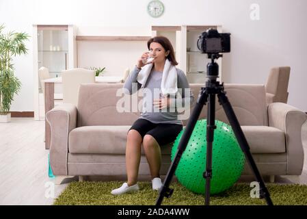 Femme enceinte blogger faisant des exercices physiques Banque D'Images