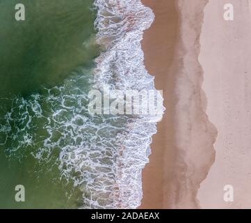 Drone photo de vagues frapper la plage. Banque D'Images
