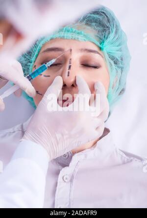 Chirurgien plastique à préparer l'opération sur visage femme Banque D'Images