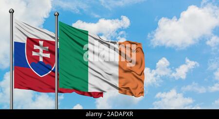 La Slovaquie et l'Irlande drapeaux dans le vent contre ciel bleu nuageux blanc ensemble. Concept de diplomatie, de relations internationales. Banque D'Images