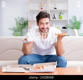 Man eating pizza à emporter à la maison avoir un repos relaxant Banque D'Images