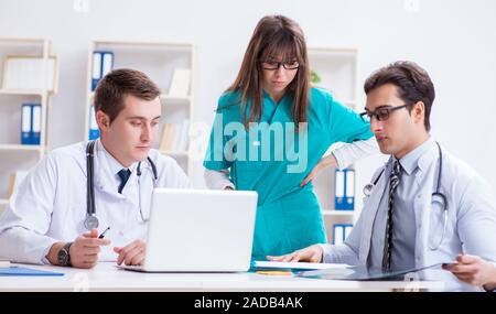 Les trois médecins de discuter des résultats de l'analyse de x-ray image Banque D'Images