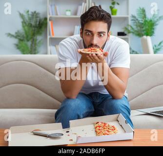 Man eating pizza à emporter à la maison avoir un repos relaxant Banque D'Images