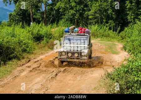 Une jeep est la conduite sur la route boueuse entre Tumlingtar et Chewabesi, aux projections d'eau Banque D'Images