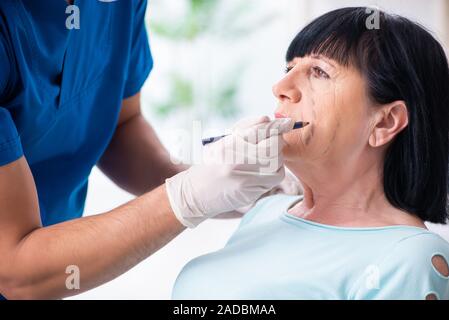 Vieille Femme visiter homme médecin pour la chirurgie en plastique Banque D'Images