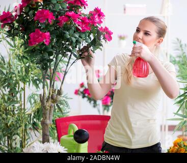 Jeune femme d'arroser les plantes de son jardin Banque D'Images