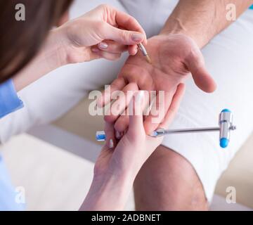 Contrôle de médecin avec un marteau réflexes nerveux Banque D'Images