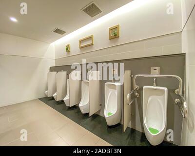 Les hommes modernes avec toilettes urinoirs en porcelaine blanche dans la ligne Banque D'Images