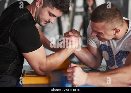 Atmosphère tendue. Arm wrestling challenge entre deux hommes. Correspondance sur un tableau spécial Banque D'Images