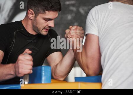 La lutte pour gagner. Arm wrestling challenge entre deux hommes. Correspondance sur un tableau spécial Banque D'Images