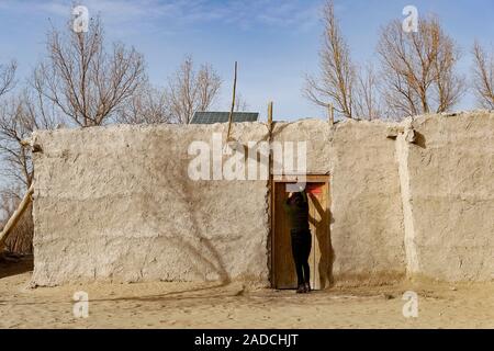 (191204) -- URUMQI , le 4 décembre 2019 (Xinhua) -- l'épouse d'Imin quitte leur ancienne maison en ville à Yutian Darya Boyi, comté du nord-ouest de la Chine La région autonome du Xinjiang Uygur, le 17 novembre 2019. Avant de passer à la nouvelle colonie le 17 novembre et le 18 novembre de cette année, la maison d'Imin berger était au coeur de l'Désert Taklimakan, le deuxième plus grand désert de sable dans le monde. Pour des centaines d'années, les ancêtres d'Imin ont installés le long de la rivière Keriya, qui coule du sud au nord jusqu'au cœur de dunes de sable sans fin, en plus comme des doigts et de fournir la source d'eau pour les droits de l'hab Banque D'Images