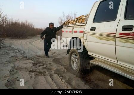 (191204) -- URUMQI, le 4 décembre 2019 (Xinhua) -- permet d'Imin pousser le véhicule en détresse sur le chemin de la zone de réinstallation pour Darya Boyi en ville Comté Yutian, nord-ouest de la Chine, la Région autonome du Xinjiang Uygur, le 17 novembre 2019. Avant de passer à la nouvelle colonie le 17 novembre et le 18 novembre de cette année, la maison d'Imin berger était au coeur de l'Désert Taklimakan, le deuxième plus grand désert de sable dans le monde. Pour des centaines d'années, les ancêtres d'Imin ont installés le long de la rivière Keriya, qui coule du sud au nord jusqu'au cœur de dunes de sable sans fin, en plus comme des doigts et provi Banque D'Images