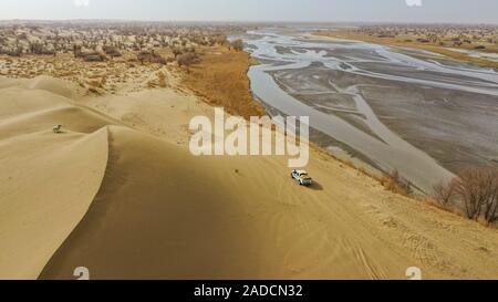 (191204) -- URUMQI, le 4 décembre 2019 (Xinhua) -- photo aérienne prise le 18 novembre 2019 montre l'Imin's family sur leur chemin un déménagement à travers le désert en comté Yutian, nord-ouest de la Chine, la Région autonome du Xinjiang Uygur. Avant de passer à la nouvelle colonie le 17 novembre et le 18 novembre de cette année, la maison d'Imin berger était au coeur de l'Désert Taklimakan, le deuxième plus grand désert de sable dans le monde. Pour des centaines d'années, les ancêtres d'Imin ont installés le long de la rivière Keriya, qui coule du sud au nord jusqu'au cœur de dunes de sable sans fin, en plus comme des doigts et providin Banque D'Images