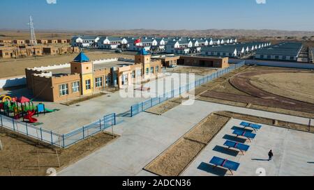 (191204) -- URUMQI, le 4 décembre 2019 (Xinhua) -- photo aérienne prise le 19 novembre 2019 montre l'école maternelle et l'école d'une zone de réinstallation pour Darya Boyi en ville Comté Yutian, nord-ouest de la Chine, la Région autonome du Xinjiang Uygur. Avant de passer à la nouvelle colonie le 17 novembre et le 18 novembre de cette année, la maison d'Imin berger était au coeur de l'Désert Taklimakan, le deuxième plus grand désert de sable dans le monde. Pour des centaines d'années, les ancêtres d'Imin ont installés le long de la rivière Keriya, qui coule du sud au nord jusqu'au cœur de dunes de sable sans fin, en plus comme des doigts et Banque D'Images