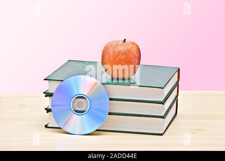 Apple, dvd, et des livres comme un symbole de la transition de l'ancienne à la nouvelle façon d'apprendre Banque D'Images