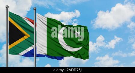 L'Afrique du Sud et le Pakistan drapeaux dans le vent contre ciel bleu nuageux blanc ensemble. Concept de diplomatie, de relations internationales. Banque D'Images