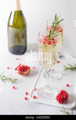 Deux verre de champagne cocktail de Noël de Grenade avec Rosemary nintendo, champagne, club soda le tableau gris. Boisson de Noël. Banque D'Images