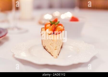 Gâteau au fromage aux fraises fraîches sur une plaque en céramique sur un tableau blanc Banque D'Images