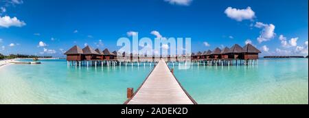 Passerelle au-dessus de l'eau peu profonde à l'eau, bungalows à l'île de South Male Atoll, Maldives Banque D'Images